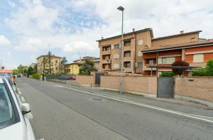 a car parked on the side of a street with buildings at Burò il Viaggiatore in Parma