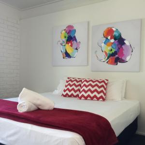 a bedroom with a bed and a painting on the wall at Arcadia Village Motel in Arcadia