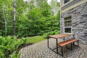 uma mesa de madeira e um banco ao lado de um edifício em Tremblant Les Eaux by Rendez-Vous Mont-Tremblant em Mont-Tremblant