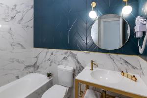 ein Badezimmer mit einem WC, einem Waschbecken und einem Spiegel in der Unterkunft Hôtel Flor in Saint-Florent