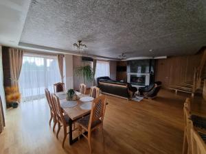 a living room with a table and a couch at Villa MAG in Druskininkai