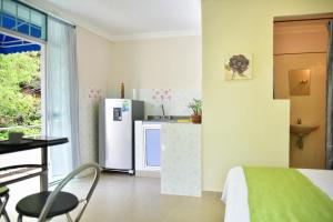 a kitchen with a refrigerator and a table with a chair at Perth House Taganga in Taganga +35 photos