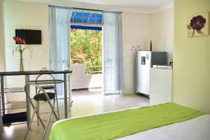 a kitchen with a refrigerator and a table in a room at Perth House Taganga in Taganga