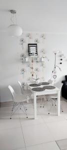 a white table and chairs with umbrellas on the wall at Apartament Polonia in Szczecin