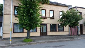 un edificio con un árbol delante de él en Emilie's Apartments en Liepāja