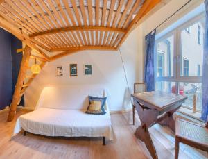a bedroom with a white bed and a table at Labyrinth Hostel Weimar in Weimar