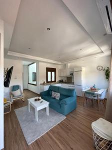 ein Wohnzimmer mit einem blauen Sofa und einem Tisch in der Unterkunft Apartamentos Cantarería, Jazmín. in Setenil de las Bodegas
