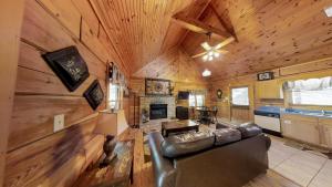 una sala de estar con un sofá de cuero en una cabaña en Cabin Fever, en Sevierville