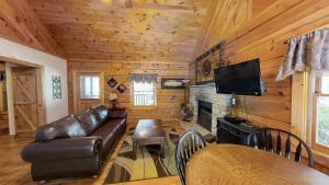 sala de estar con sofá de cuero y chimenea en Cabin Fever, en Sevierville