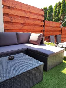 a blue couch sitting on the grass in a yard at Flower Apartment in Hévíz