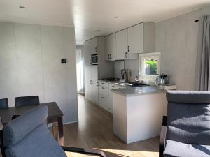 a kitchen with white cabinets and a counter top at Doelweg 35 Chalet 172 in Goedereede