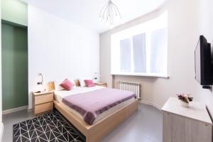 1 dormitorio con 1 cama con almohadas rosas en ХостелыРУС - Тюмень, en Tyumen