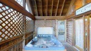 a room with a tub in a wooden house at Cozy Cottage Unit 1610 Cabin in Waldens Creek
