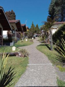 a walkway through a yard with houses and trees at Chalés 4 Estações in Monte Verde