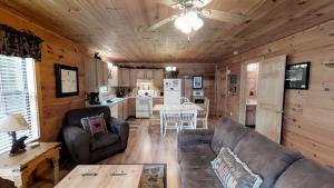 a living room with a couch and a table and a kitchen at Paw Prints Mountain View Cabin in Sevierville