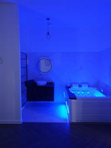 Habitación azul con bañera y lavamanos en Suite Miro Charme et volupté, en Perpiñán