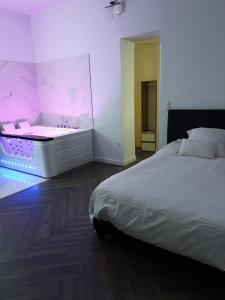 a bedroom with a white bed and a bath tub at Suite Miro Charme et volupté in Perpignan