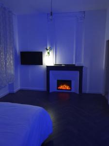 Habitación azul con chimenea y cama en Suite Miro Charme et volupté, en Perpiñán