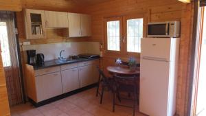 eine Küche mit einem weißen Kühlschrank und einem Tisch in der Unterkunft Villa Soroni in Soroni