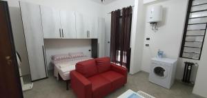 ノヴァーラにあるCasa Manzoniのリビングルーム(赤い椅子、洗濯機付)