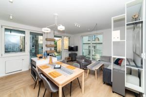 a kitchen and living room with a table and chairs at 5o5 Deluxe by OneApartments in Sopot