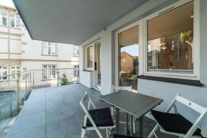 a patio with a table and chairs on a balcony at 5o5 Deluxe by OneApartments in Sopot