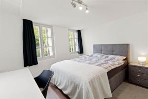 - une chambre blanche avec un lit et une chaise dans l'établissement GUEST HOUSE HERMES Contactless Self Checkin, à Zurich