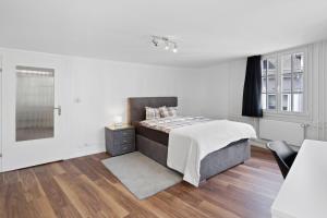una camera da letto bianca con un letto e una televisione di GUEST HOUSE HERMES Contactless Self Checkin a Zurigo