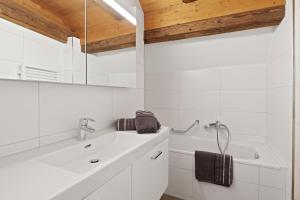 un bagno bianco con vasca e lavandino di GUEST HOUSE HERMES Contactless Self Checkin a Zurigo