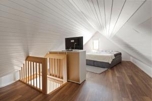 a bedroom with a bed and a tv in a attic at GUEST HOUSE HERMES Contactless Self Checkin in Zürich