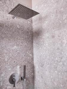 a bathroom with a shower with a light on the wall at Room45 in Marzamemi