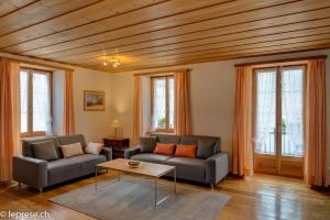 ein Wohnzimmer mit 2 Sofas und einem Tisch in der Unterkunft Casa Zanetti in Poschiavo