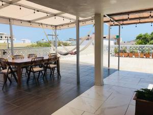 d'une terrasse avec une table, des chaises et un hamac. dans l'établissement Hosteleria Casa Margarita, à Mazatlán