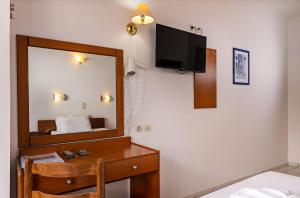 a hotel room with a mirror and a desk and a bed at Hotel Kathrin Beach in Adelianos Kampos