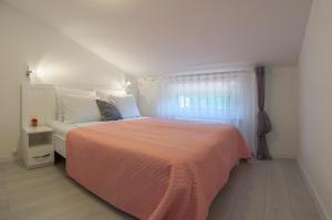 a bedroom with a large bed with a orange blanket at Apartments SoMi in Poreč