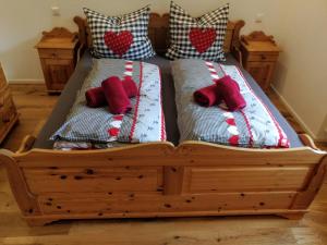 un letto in legno con due cuscini sopra di Ferienwohnung am Bach a Missen-Wilhams