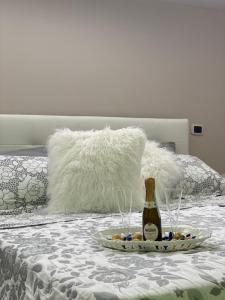 una bottiglia di champagne e un piatto di cibo su un letto di La stella di Mery casa vacanze a Gragnano