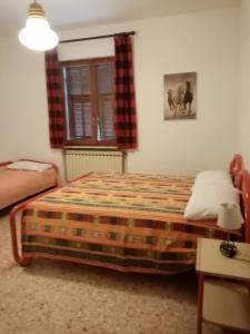 Schlafzimmer mit einem Bett und einem Fenster in der Unterkunft IL VIGNETO in Diano Castello