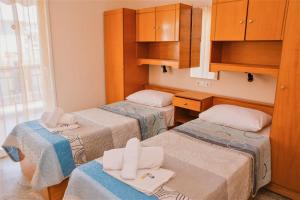 Habitación con 2 camas y armarios de madera. en Apartments Tania, en Paralia Dionisiou