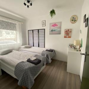 ボルガルネースにあるPrivate Scandinavian Apartmentの白い壁のベッドルームにツインベッド2台が備わります。