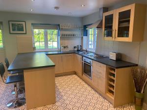 a kitchen with wooden cabinets and a black counter top at Relaxing Retreat Around Nature in Wrexham