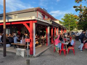 a group of people sitting at tables outside a restaurant at L'Escasse in Lit-et-Mixe