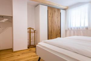 - une chambre avec un lit blanc et une fenêtre dans l'établissement Innermoarhof, à Rifiano