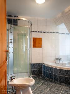 y baño con ducha, lavabo y bañera. en Moai Home Apartman Sárvár en Sárvár