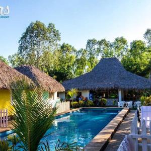 ein Pool mit zwei Hütten und ein Resort in der Unterkunft Las Dunas Surf Resort in Aposentillo