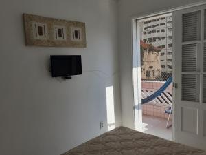 Телевизор и/или развлекательный центр в Apartamento Vento e mar - 2 quartos com sacada na quadra da praia com sauna a vapor