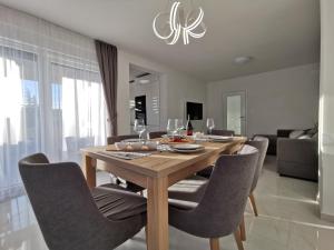 een eetkamer met een houten tafel en stoelen bij Apartments Ivana in Sveti Filip i Jakov