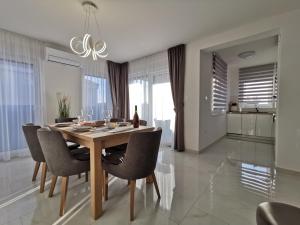 a dining room with a wooden table and chairs at Apartments Ivana in Sveti Filip i Jakov