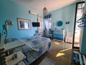 una camera da letto con pareti blu, un letto e un comò di B&B Ondamarina a Lascari