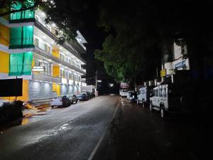 a city street at night with cars parked next to buildings at Hotel GANANJAYA in Gokarna